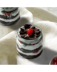 Gluten free Black Forest jar cake with chocolate layers, whipped cream, and cherries in a glass jar